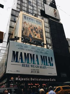 there is a large poster on the side of this building that says mamma mia here we go again