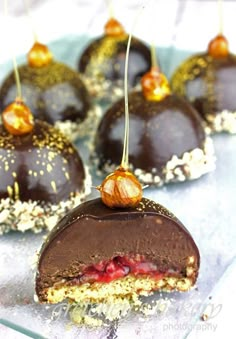 chocolate covered desserts with cherries and nuts are on a blue plate, ready to be eaten