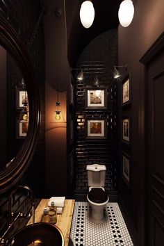 a bathroom with a toilet, sink and pictures on the wall in it's walls