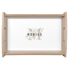 a wooden tray with the word monica in black and white on it, against a white background