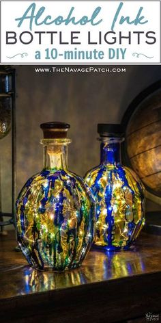 two glass vases sitting on top of a table next to each other with lights in them