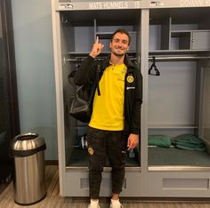 a man standing in front of lockers giving the peace sign