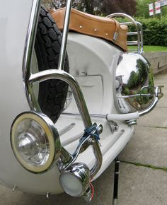 the front end of a white motorcycle parked in a driveway