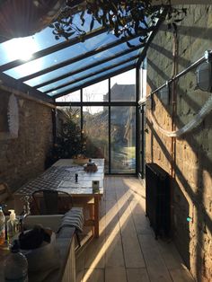 the sun shines through an open glass roofed room with a table and chairs