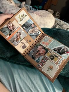 an open book with pictures and stickers on it sitting on top of a bed