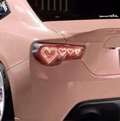 a pink car with hearts on the tail light