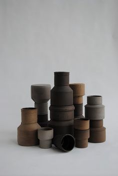 a stack of vases sitting on top of each other in front of a white background