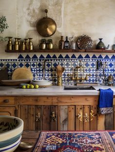 a kitchen with blue and white tiles on the wall, wooden cabinets and counter tops