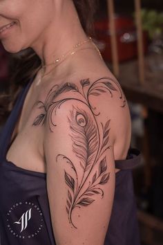 a woman with a feather tattoo on her arm