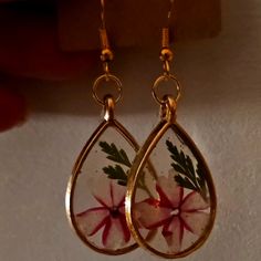 a pair of earrings with flowers painted on them