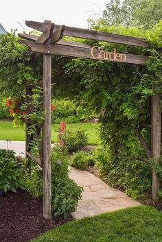 a wooden garden arch with the word garden on it in front of some bushes and trees