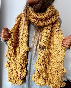 a woman wearing a yellow knitted scarf