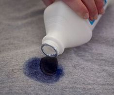 a person is using a bottle to fill up the floor with blue stuff on it