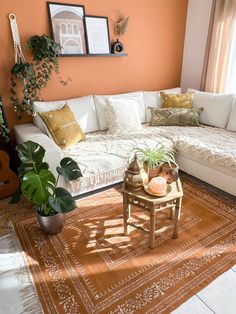 a living room with orange walls and white furniture