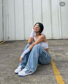 a woman sitting on the ground with her head in her hands