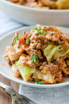 a white plate topped with cabbage and meat covered in seasoning on top of a wooden table