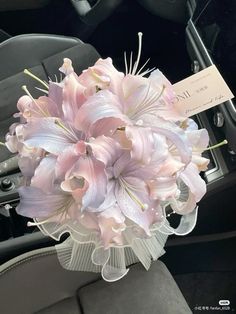 a bouquet of pink flowers sitting in the passenger seat of a car with a price tag on it