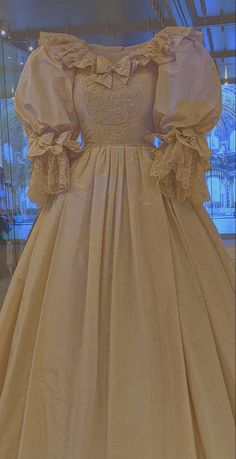 an old fashioned dress on display in a glass case