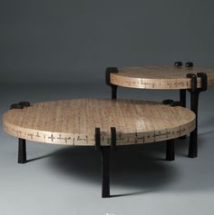 two wooden tables sitting on top of each other in front of a gray wall and floor