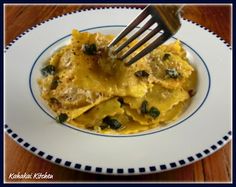 a fork is stuck into some ravioli with spinach and cheese on a white plate