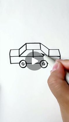 someone is drawing a car on paper with a white marker and black marker, while holding a pen in their left hand