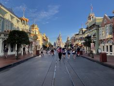 many people are walking down the street in front of buildings