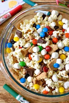 a glass bowl filled with marshmallows, m & m's and candy