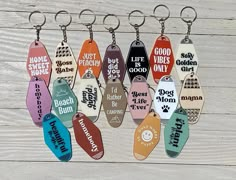 six keychains with different designs on them hanging from wooden planks, one has the words home sweet home