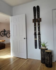 a pair of skis hanging on the wall next to a tree stump with a potted plant