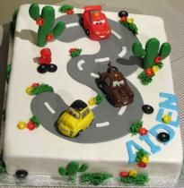 a birthday cake with cars on the road