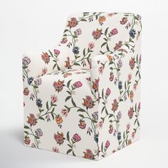 a white chair with colorful flowers on it's back and armrests, sitting in front of a white background