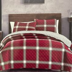 a red and white plaid comforter set on a bed