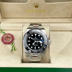 This timepiece is a Rolex GMT-Master II, a renowned model celebrated for its dual time-zone functionality and robust design. Its black dial with luminous markers ensures easy readability, complemented by a black Cerachrom ceramic bezel with a 24-hour scale. The watch features the classic Oyster bracelet in stainless steel, providing durability and comfort. Powered by either the Caliber 3186 or 3285, this watch guarantees exceptional precision and a power reserve of up to 70 hour. Luxury Black Diamond Watch With Diamond Hour Markers, Black Diamond Watch With Diamond Hour Markers, Black Diamond Watch With Round Dial, Designer Black Diamond Watch With Diamond Hour Markers, Black Diamond Watch With Chronograph, Black Diamond Watch With Subdials, Luxury Black Diamond Watch With Tachymeter, Black Diamond Watch With Subdials And Rectangular Dial, Luxury Black Diamond Watch With Round Dial