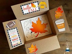 an open cardboard box with some fall stickers on it and other items around it