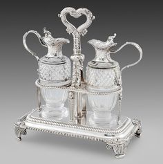 two silver - plated tea and coffee service pieces on a tray with heart handles