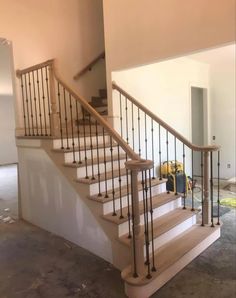 a stair case with wrought iron railing and wood handrails