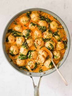 a skillet filled with meatballs and spinach