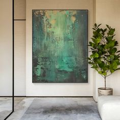 an abstract painting hangs on the wall next to a potted plant in a white room