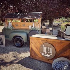 an old truck is parked in front of a small bar with wine glasses on it