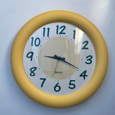 a yellow and white clock hanging on the wall