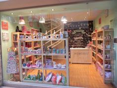 the inside of a store with lots of shelves and items on display in it's windows