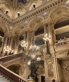 an ornately decorated building with chandeliers and marble staircase leading up to the second floor