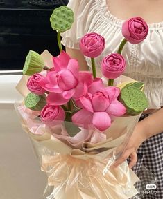 a woman holding a bouquet of pink flowers