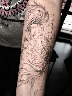 a woman's arm with a dragon tattoo on the left side of her arm