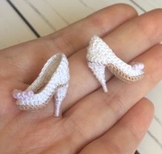 small crocheted shoes are being held in someone's hand