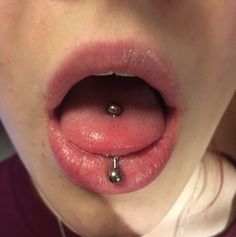 a close up of a person's tongue and nose piercing