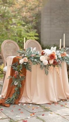 a table with flowers and candles on it is set up for an outdoor wedding reception