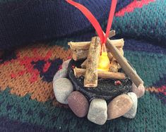 an ornament made out of rocks and wood with a lit candle in it