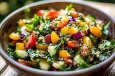 a bowl filled with lots of different types of vegetables on top of a wooden table