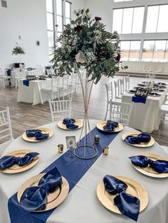 the table is set with blue and gold plates, napkins, and centerpieces